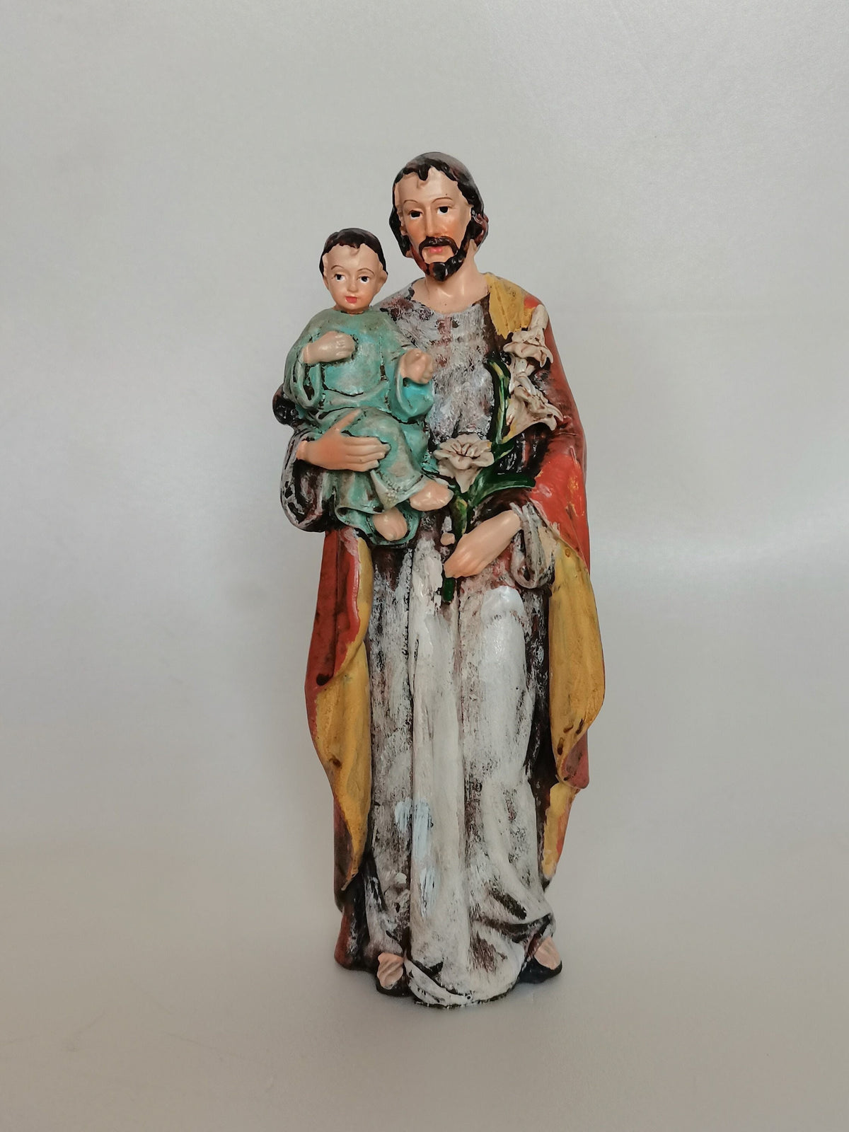 Statue Heiliger Josef mit Jesuskind und Lilie aus bemaltem Kunstharz – 15 cm